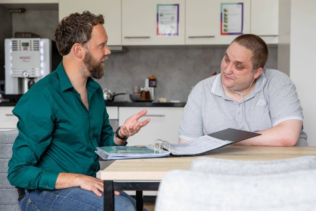 begeleider met cliënt aan tafel